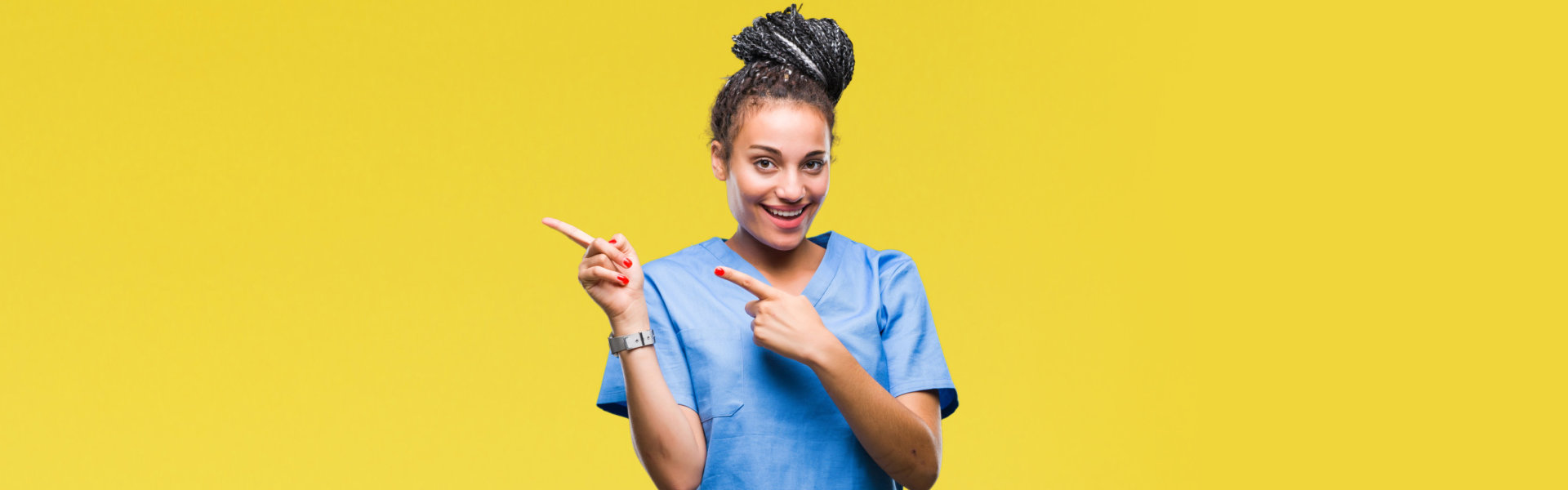 Young braided hair female nurse over isolated background smiling and pointing with two hands and fingers to the side