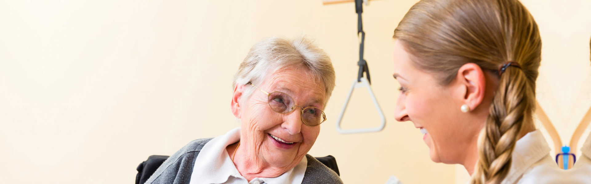 Nurse taking care of senior women in retirement home bandaging a wound